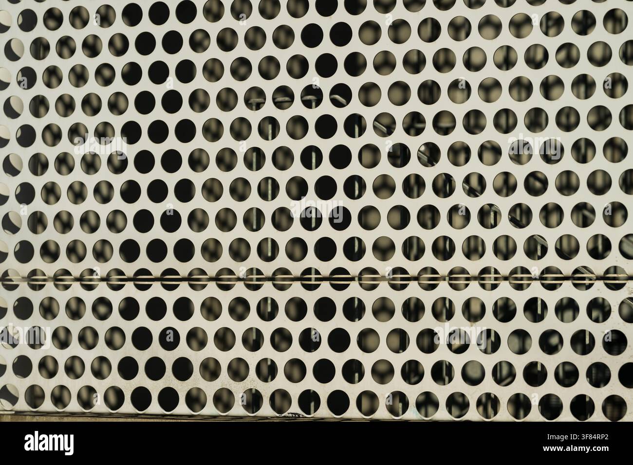 Patterned perforated metal panel with circular holes Stock Photo
