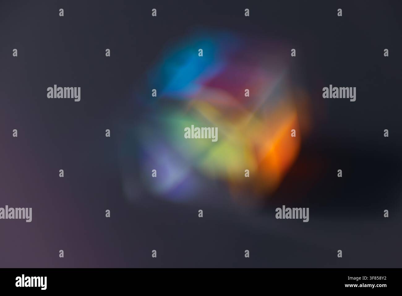Soft blurred rainbow light refraction forming colorful circular glow on dark background for dreamy abstract design Stock Photo