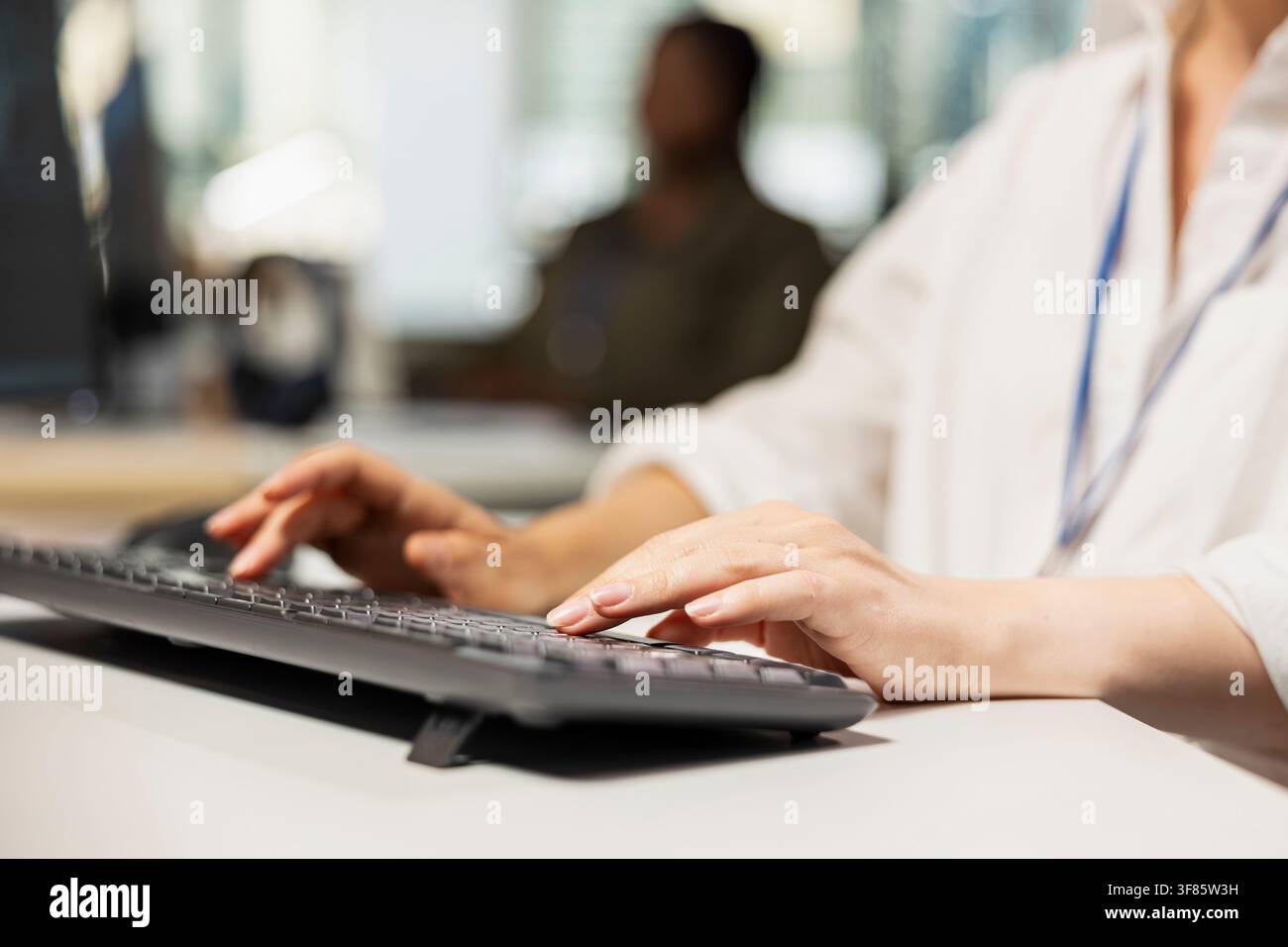 Close up of programmer in Silicon Valley company office developing software using PC, writing code. IT professional typing on computer keyboard, debugging applications to resolve issues Stock Photo