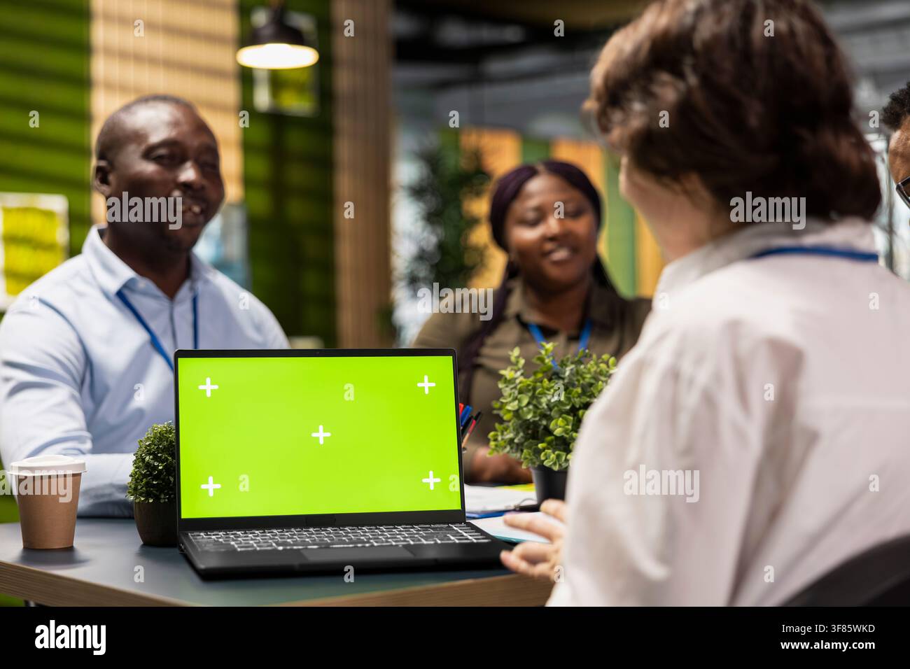 Green screen laptop next to programmers brainstorming ways to develop applications in startup office. Engineers optimizing performance with mockup notebook by debugging application code Stock Photo
