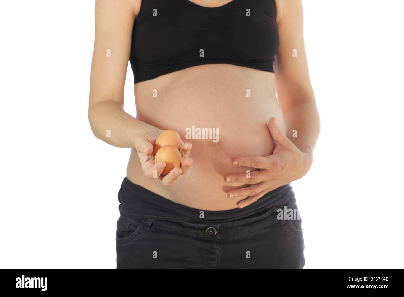 Pregnant woman holding eggs, isolated on white background Stock Photo