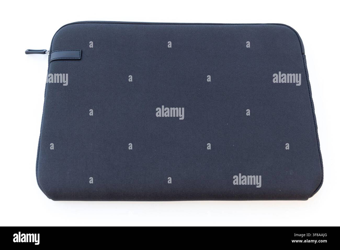 A dark blue laptop sleeve with a zipper lies on a white surface Stock Photo