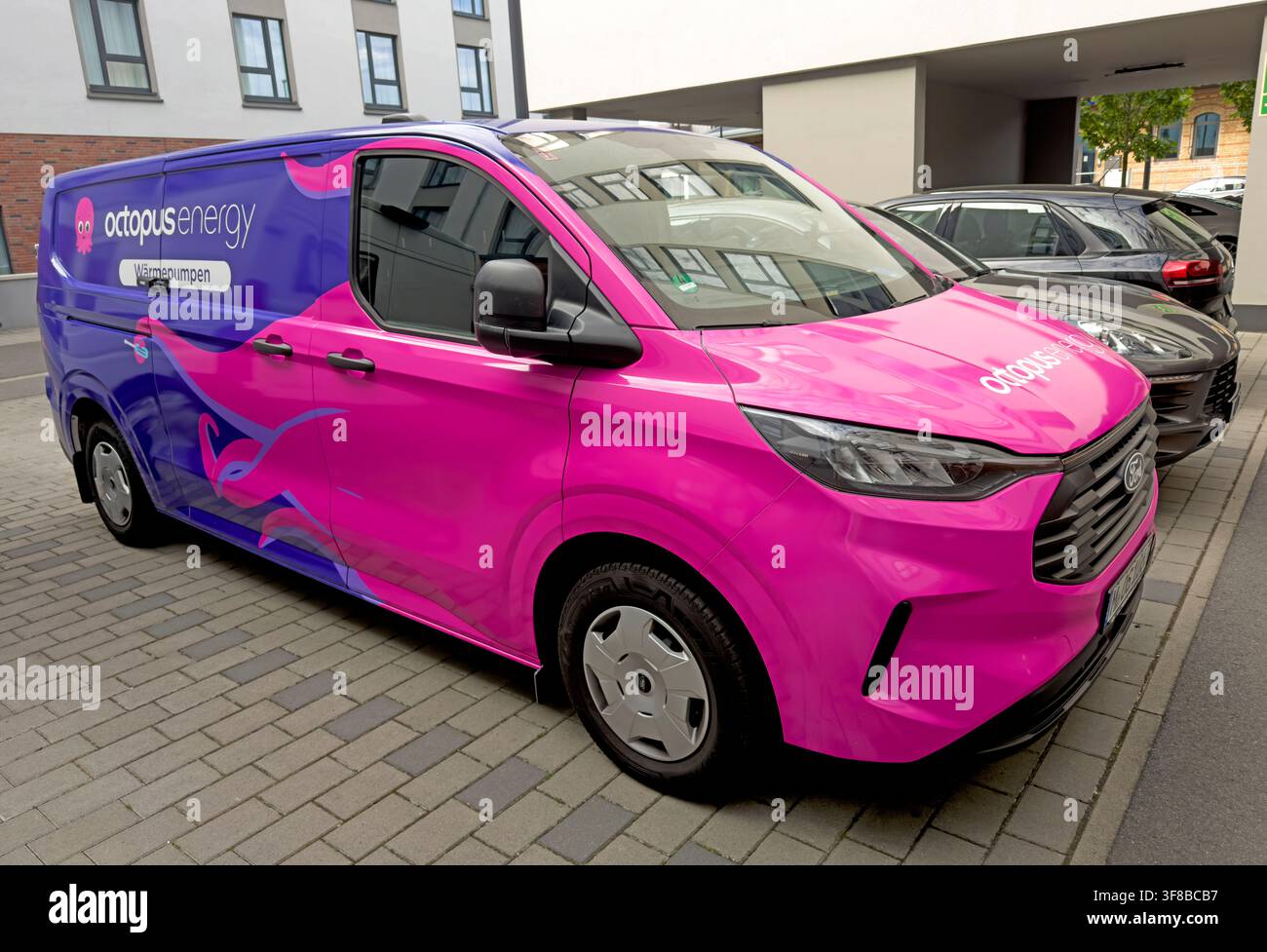 Pink and purple Octopus Energy Wärmepumpen service van on call in Mainz, Germany, reflecting the shift to low-carbon home heating. Stock Photo