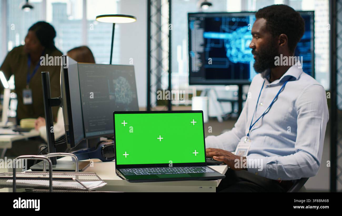 Startup office programmer using green screen laptop, developing artificial intelligence models for business analytics. IT expert using mockup notebook, running simulations for AI forecasting, camera A Stock Photo