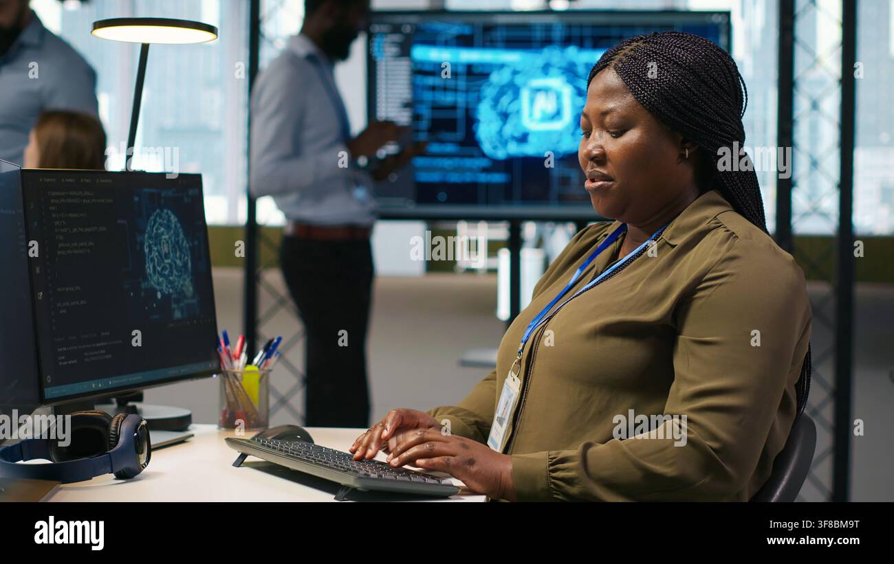 Female technician writing code on PC, developing neural networks APIs. System administrator using computer to troubleshoot software errors with artificial intelligence technology, camera A Stock Photo