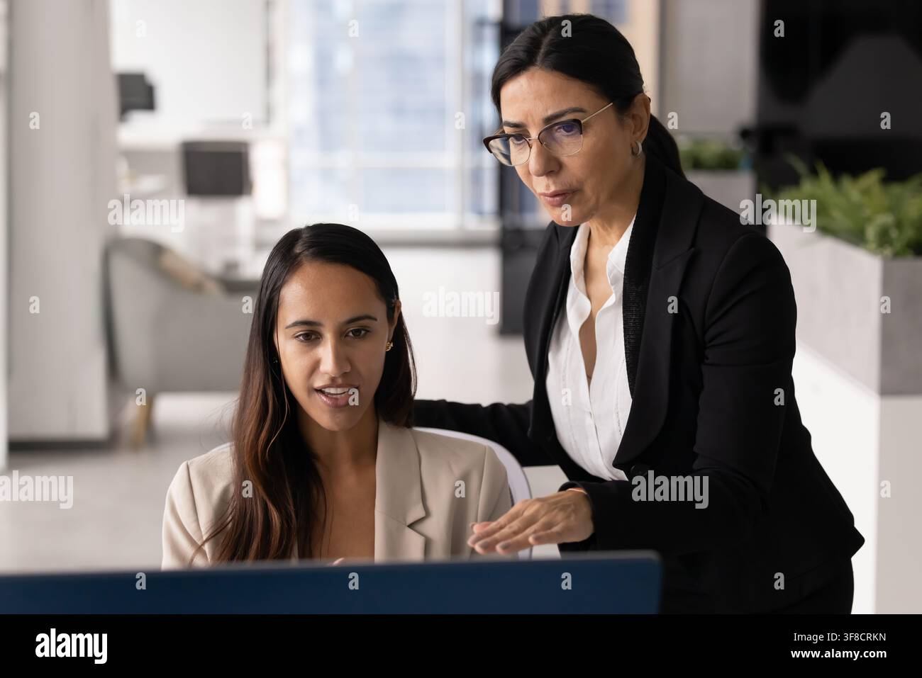 Multiethnic team members reviewing information on computer screen Stock Photo
