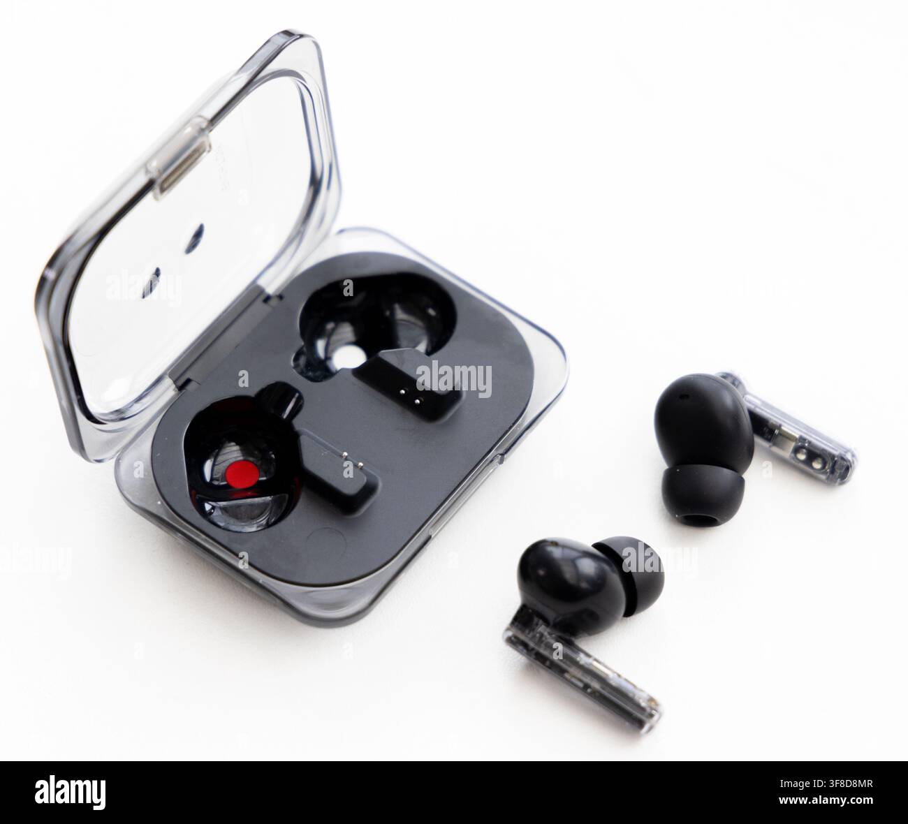 Wireless earbuds and an open charging case on white background Stock Photo