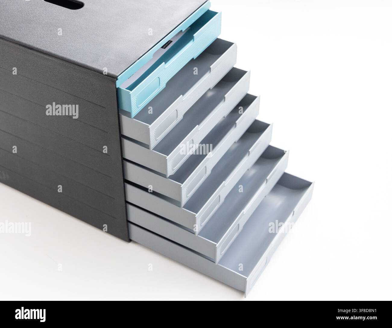 A modern plastic desk organizer with multiple open sliding drawers Stock Photo