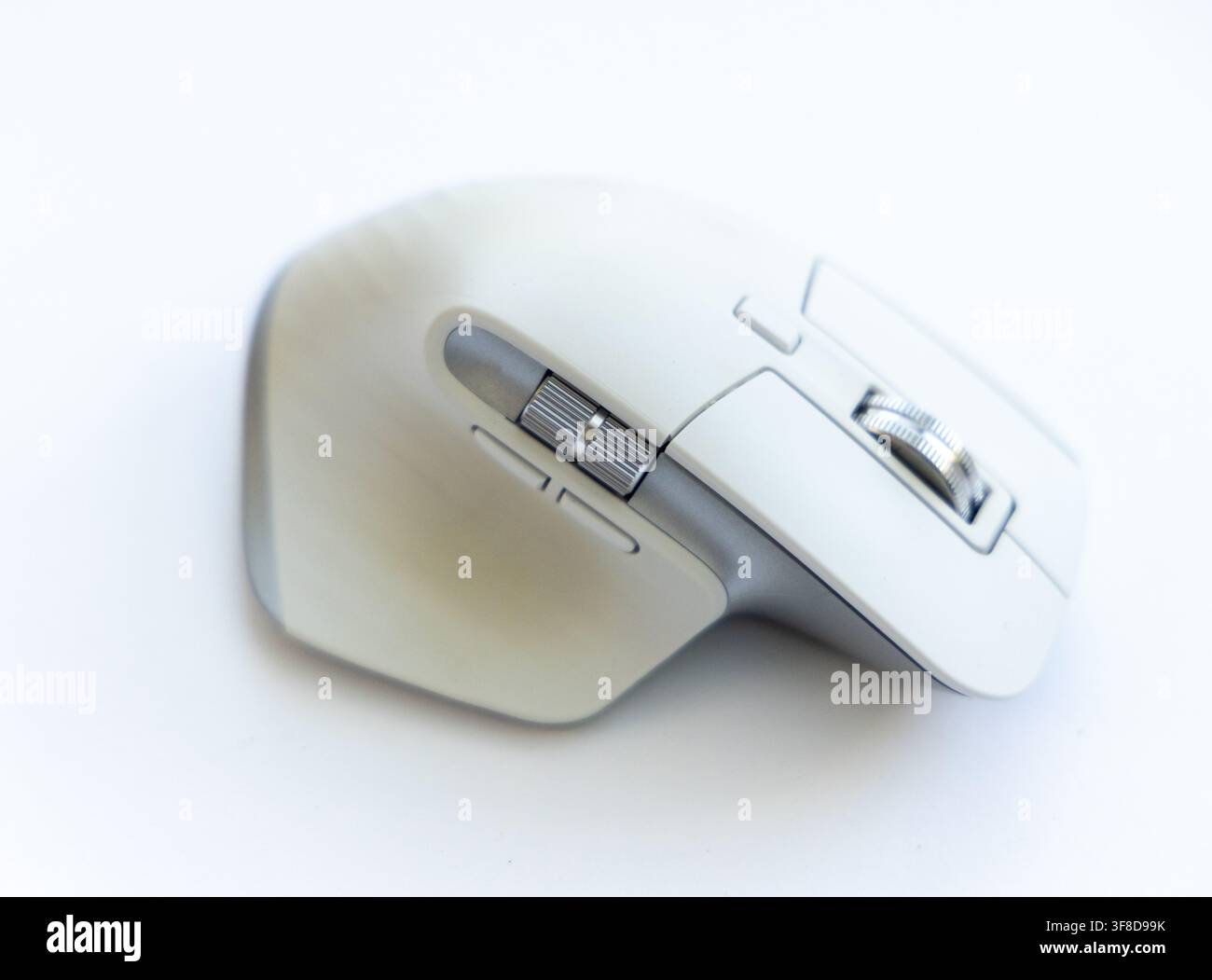 A modern wireless computer mouse sits on a white surface Stock Photo ...