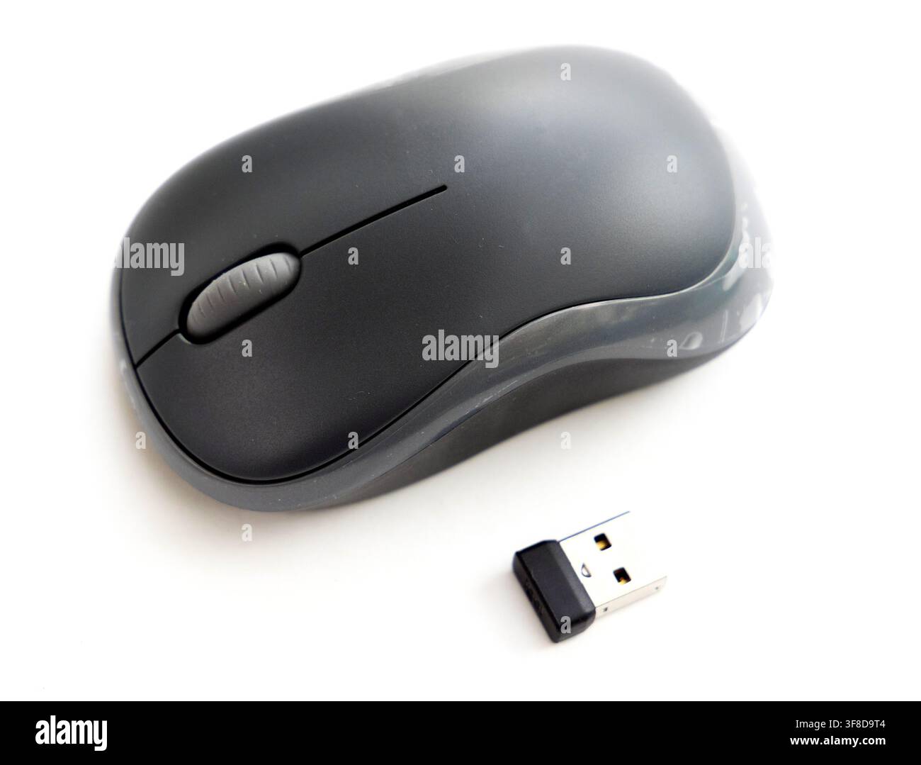 A wireless computer mouse and USB receiver on a white background Stock Photo