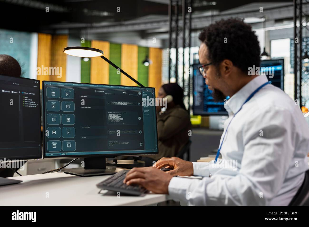 IT worker in AI tech company workplace using LLM chatbot to conduct code reviews. Developer using large language model program at office desk to design and implement machine learning algorithms Stock Photo
