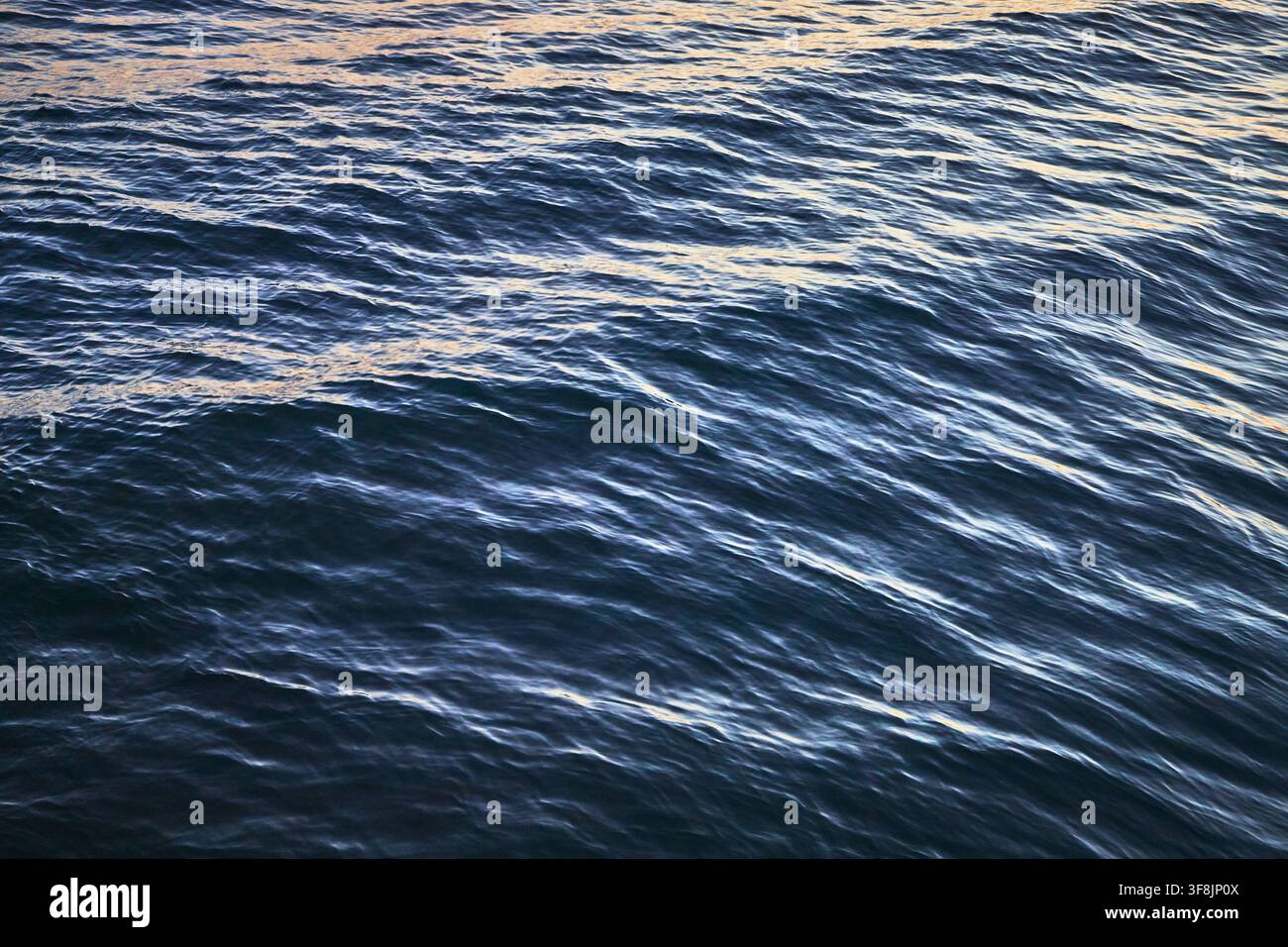 Ocean Surface Close Up with Sunlight Reflections and Gentle Waves Stock Photo