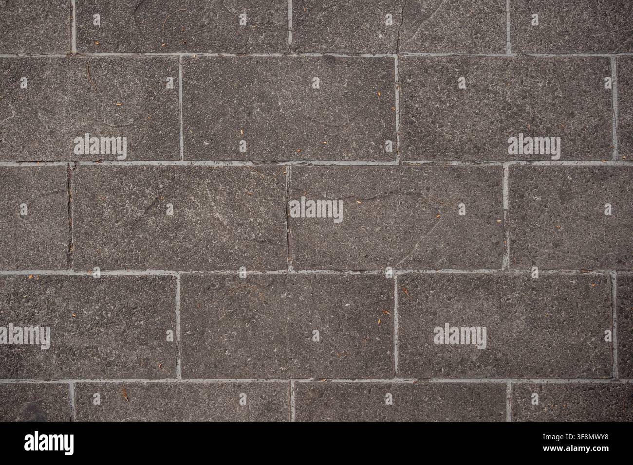 Top view of grey rectangular paving stones forming a textured brick pattern. Stock Photo