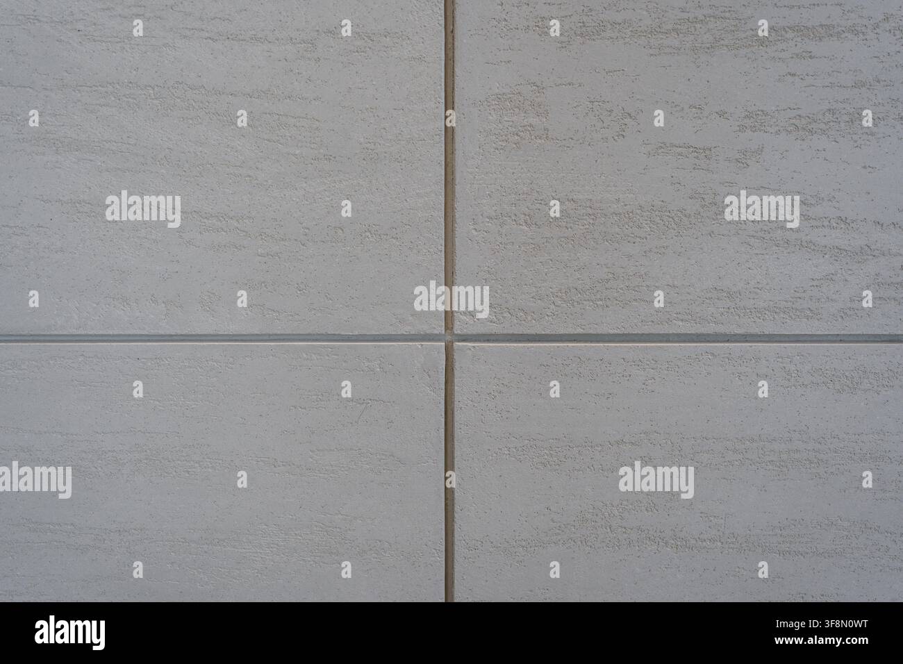 Light grey textured wall panel background featuring a symmetrical cross joint. Stock Photo