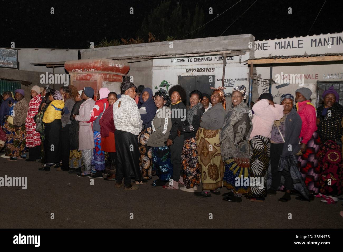 Zambians queue outside a polling station on the outskirts of Lusaka ...