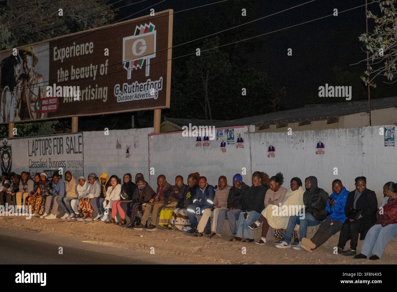 Zambians queue outside a polling station on the outskirts of Lusaka ...