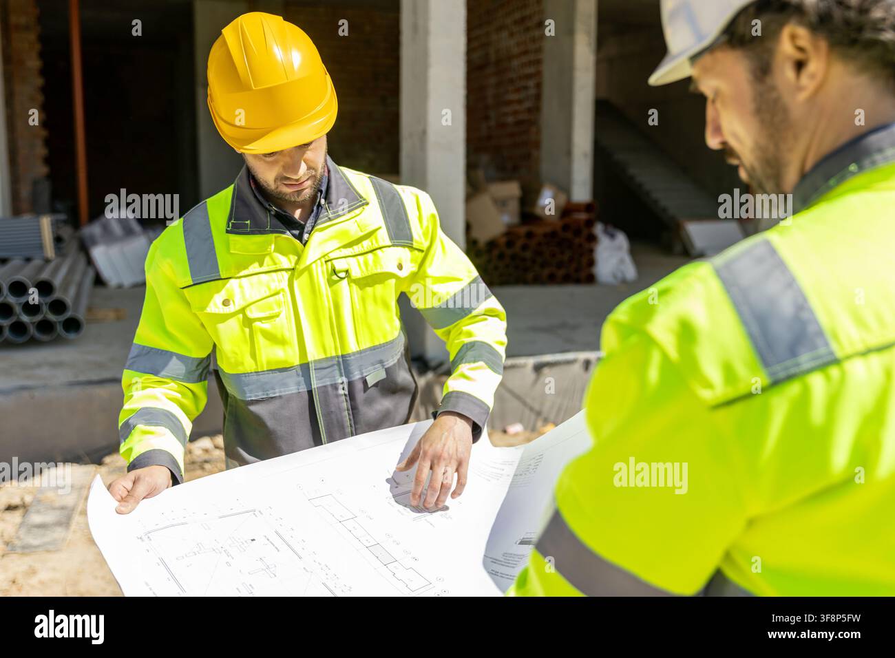 Professional builders analyzing blueprint architectural scheme Stock Photo