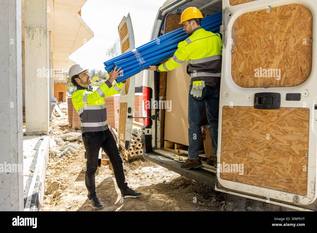 Professional builders moving blue plastic pipeline elements Stock Photo