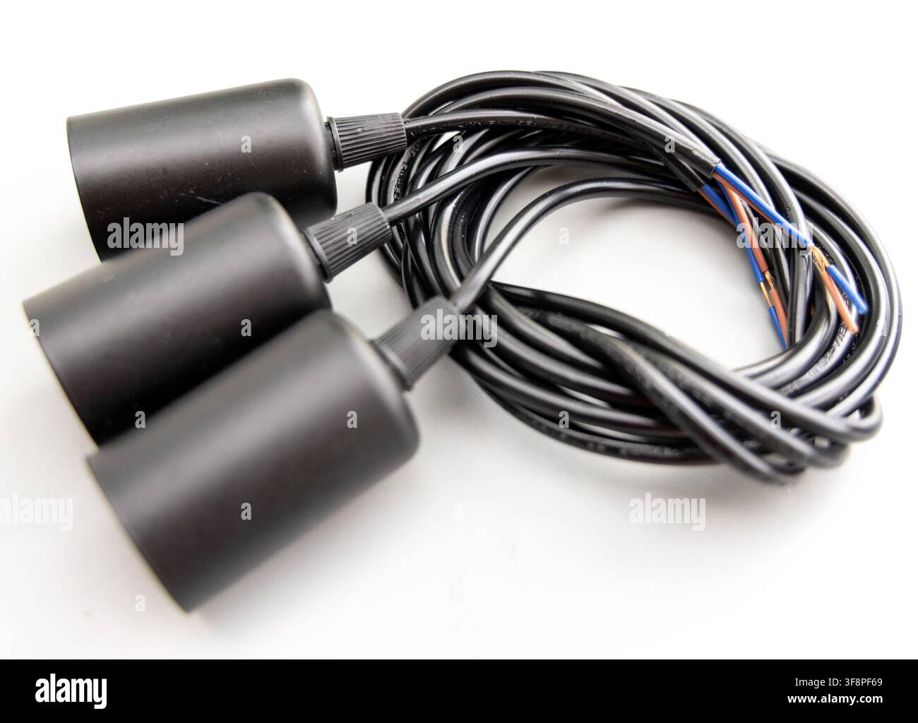 Three black lamp holders are connected to coiled electrical wire Stock Photo