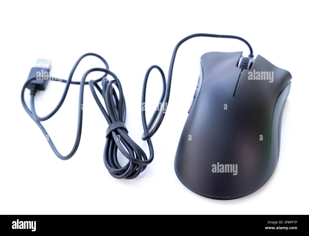 A black wired computer mouse rests on a clean white background Stock Photo