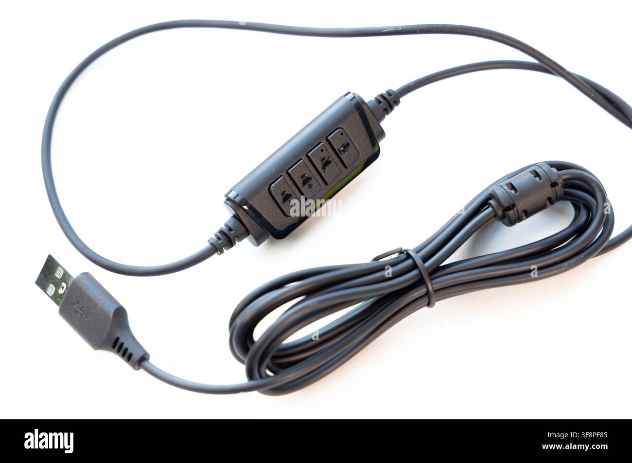 A black USB cable with inline audio controls rests on a white background Stock Photo