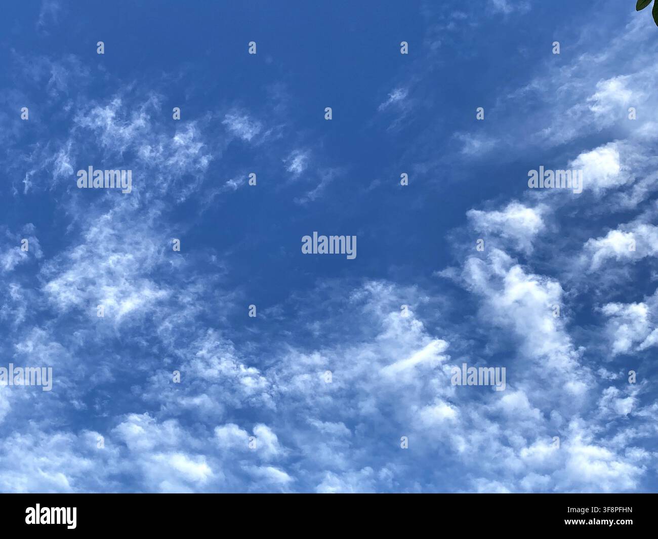 Deep blue sky with wispy white clouds Stock Photo