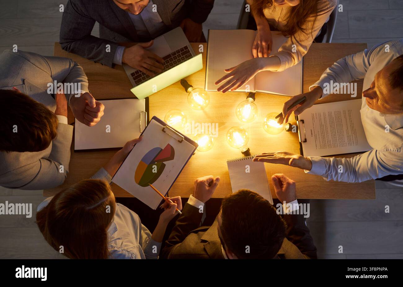 Coworkers Working With Light Bulbs In Office Stock Photo