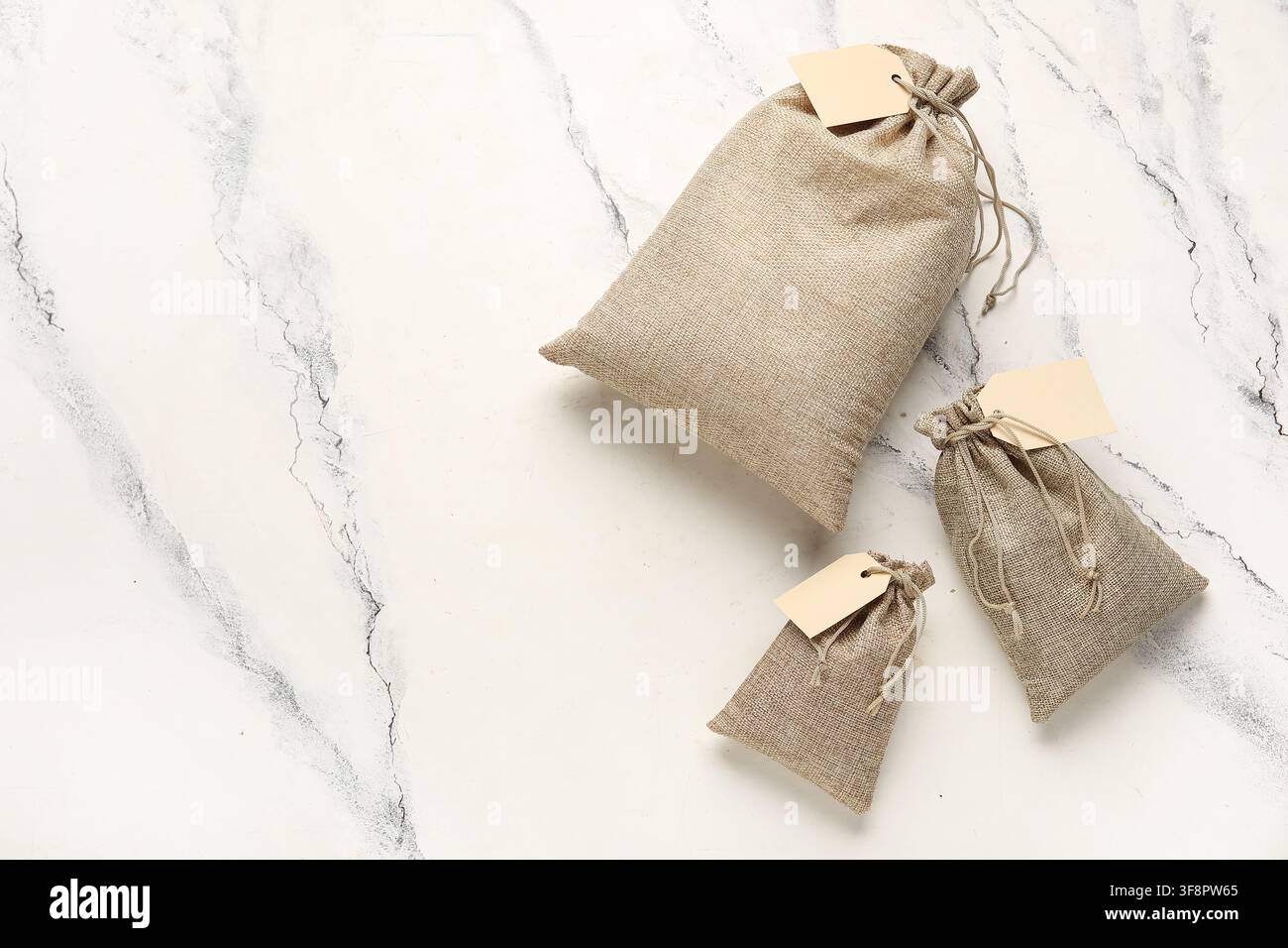 Full sacks with tags on grunge white background Stock Photo