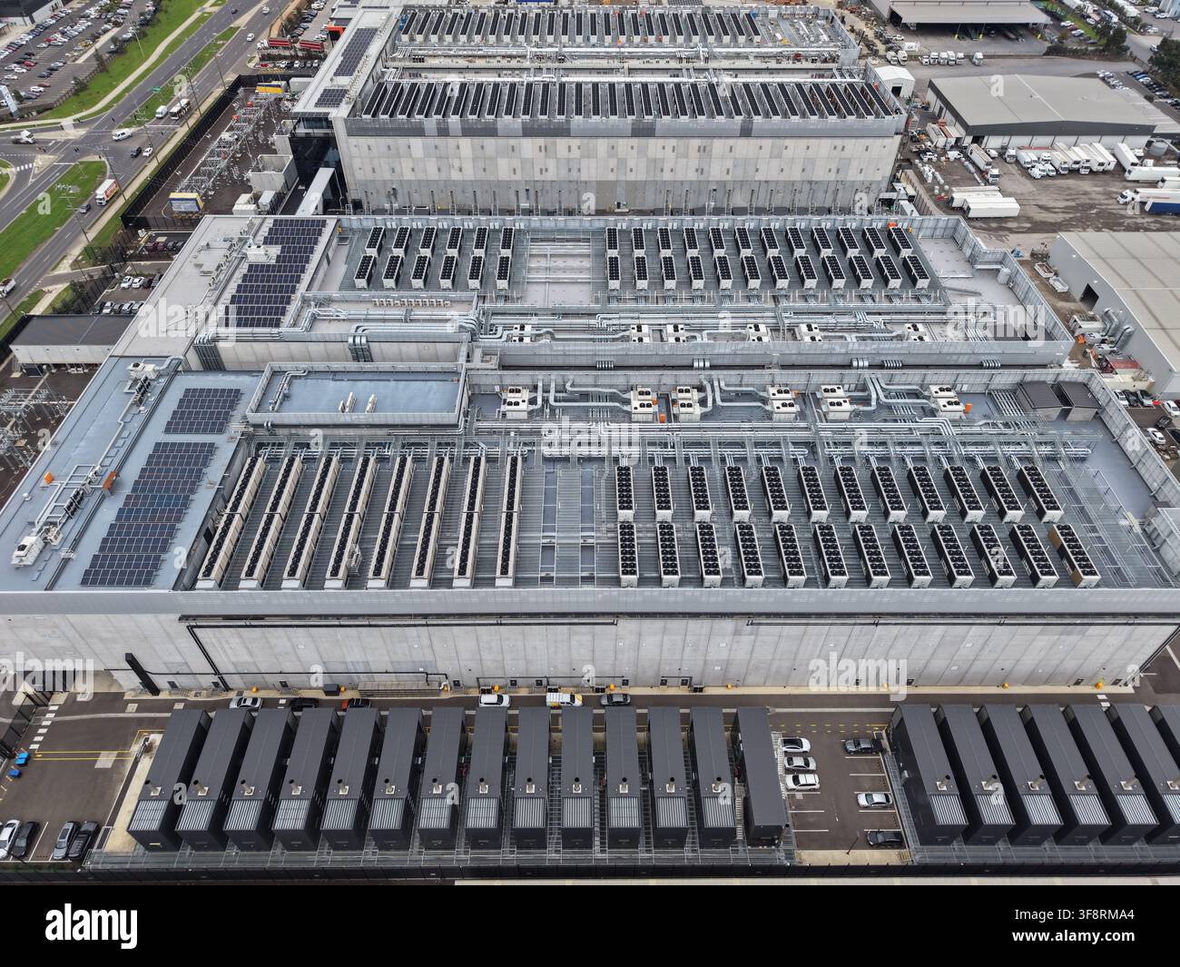 Large data center complex showing modular server units, cooling systems, and solar panels for cloud technology and digital services Stock Photo