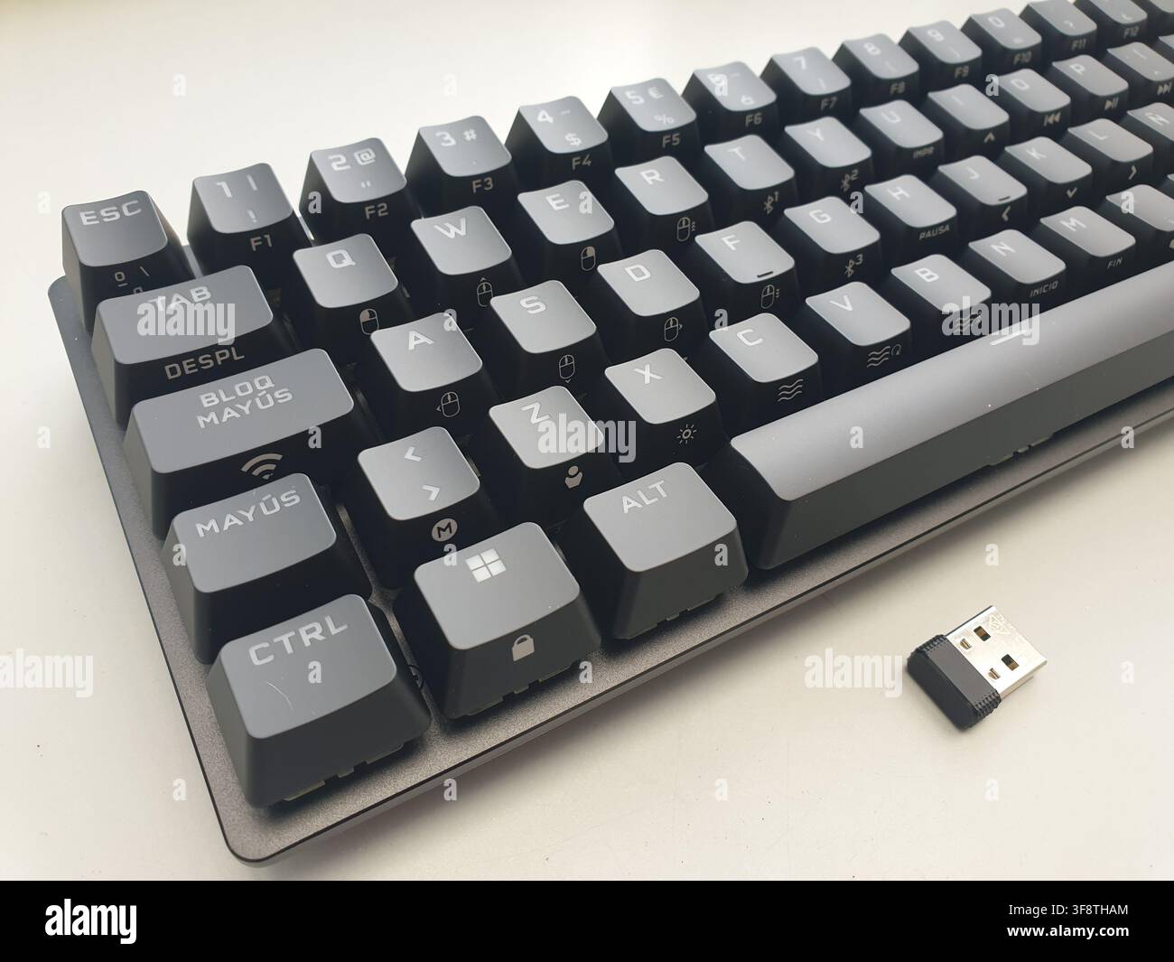 A compact wireless computer keyboard and its USB receiver are visible Stock Photo