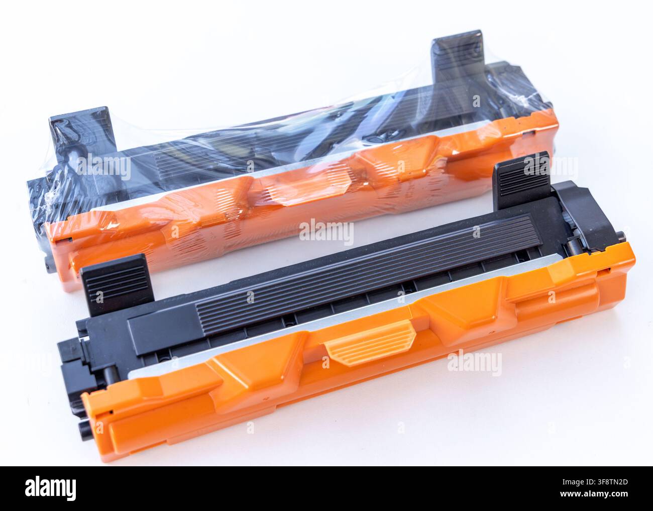 Two new black and orange printer toner cartridges are on white Stock Photo