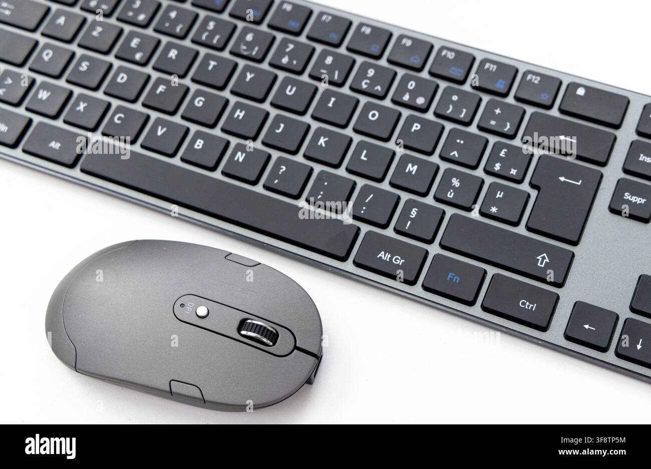 A black wireless keyboard and mouse rest on a white surface Stock Photo