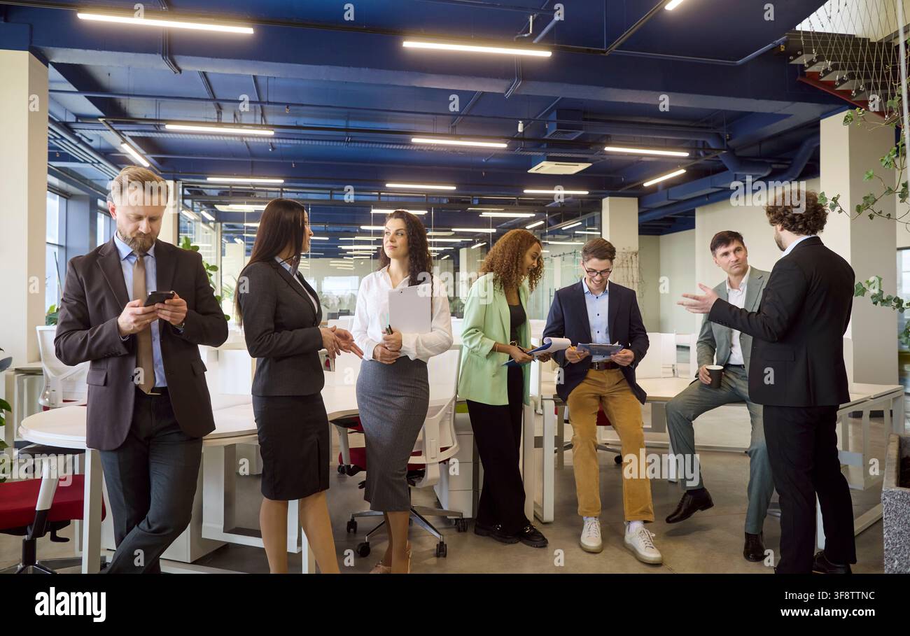 Diverse professionals networking and collaborating in a bright modern office Stock Photo