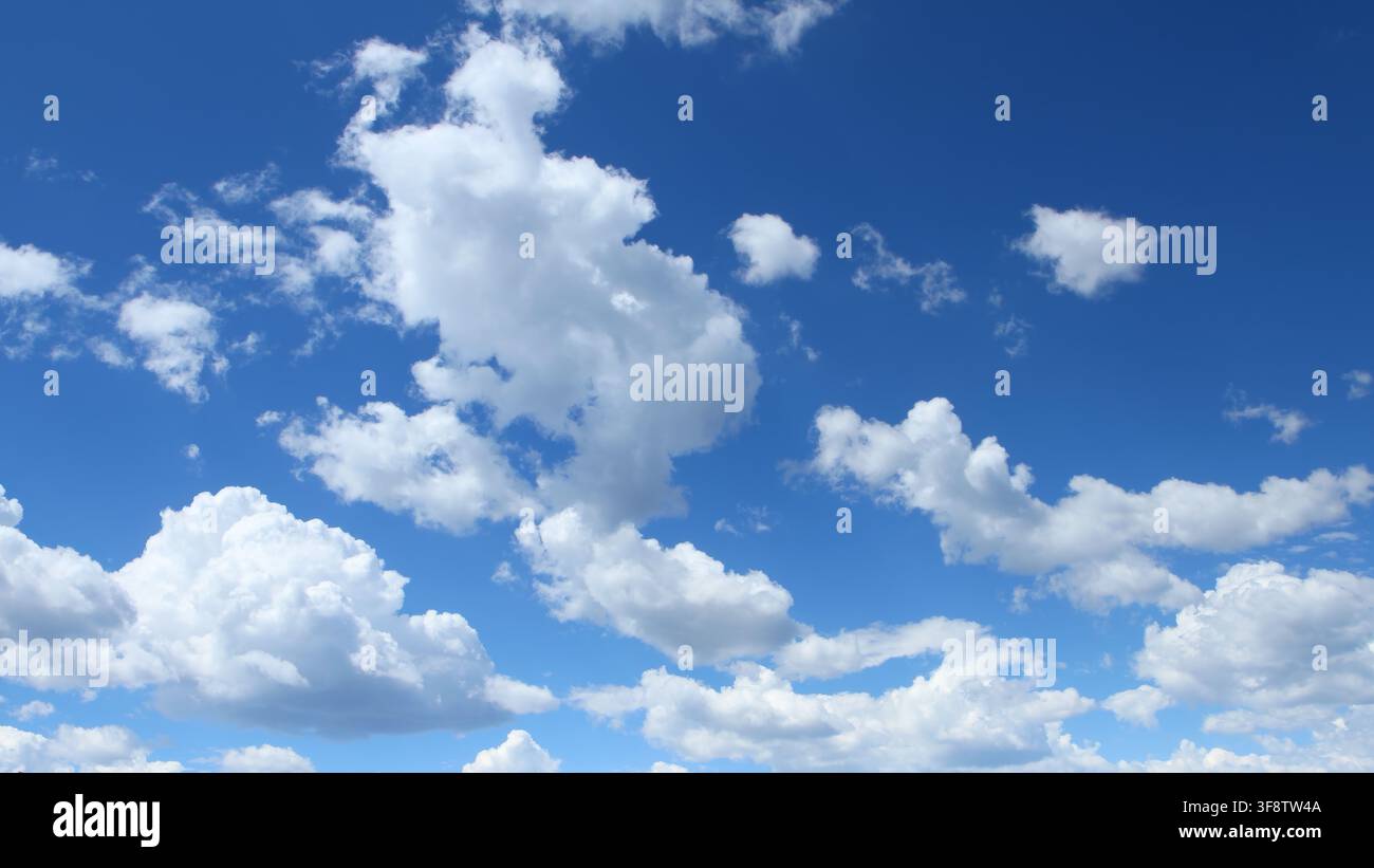 Puffy White Clouds in Blue Summer Sky Background Stock Photo