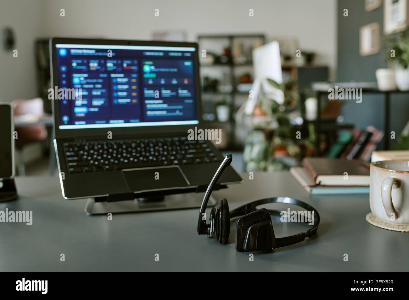 Headset on Desk with Laptop Displaying Customer Support Dashboard Stock Photo