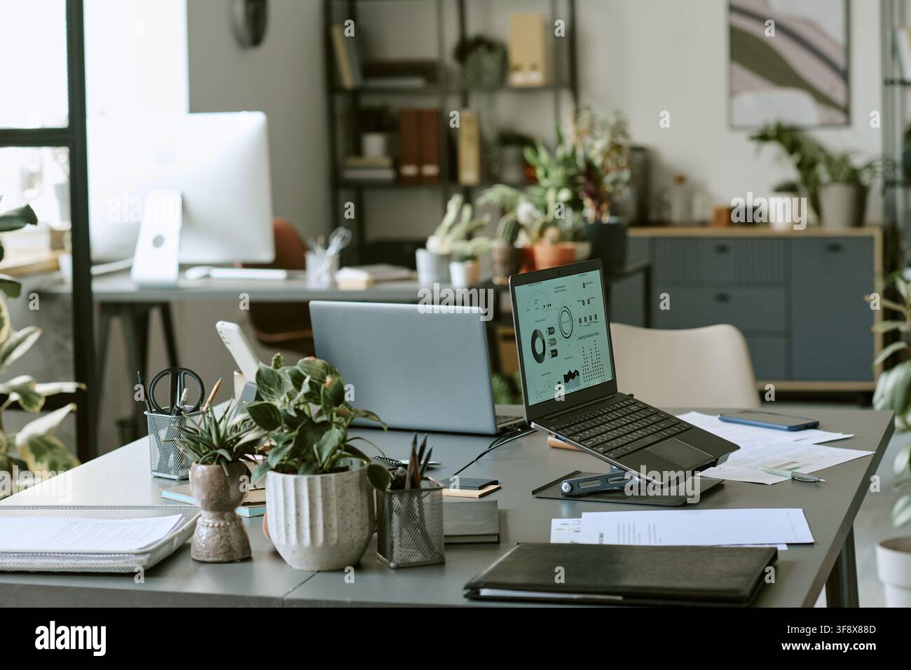 Empty Modern Office Workspace with Laptops Showing Financial Data Stock Photo