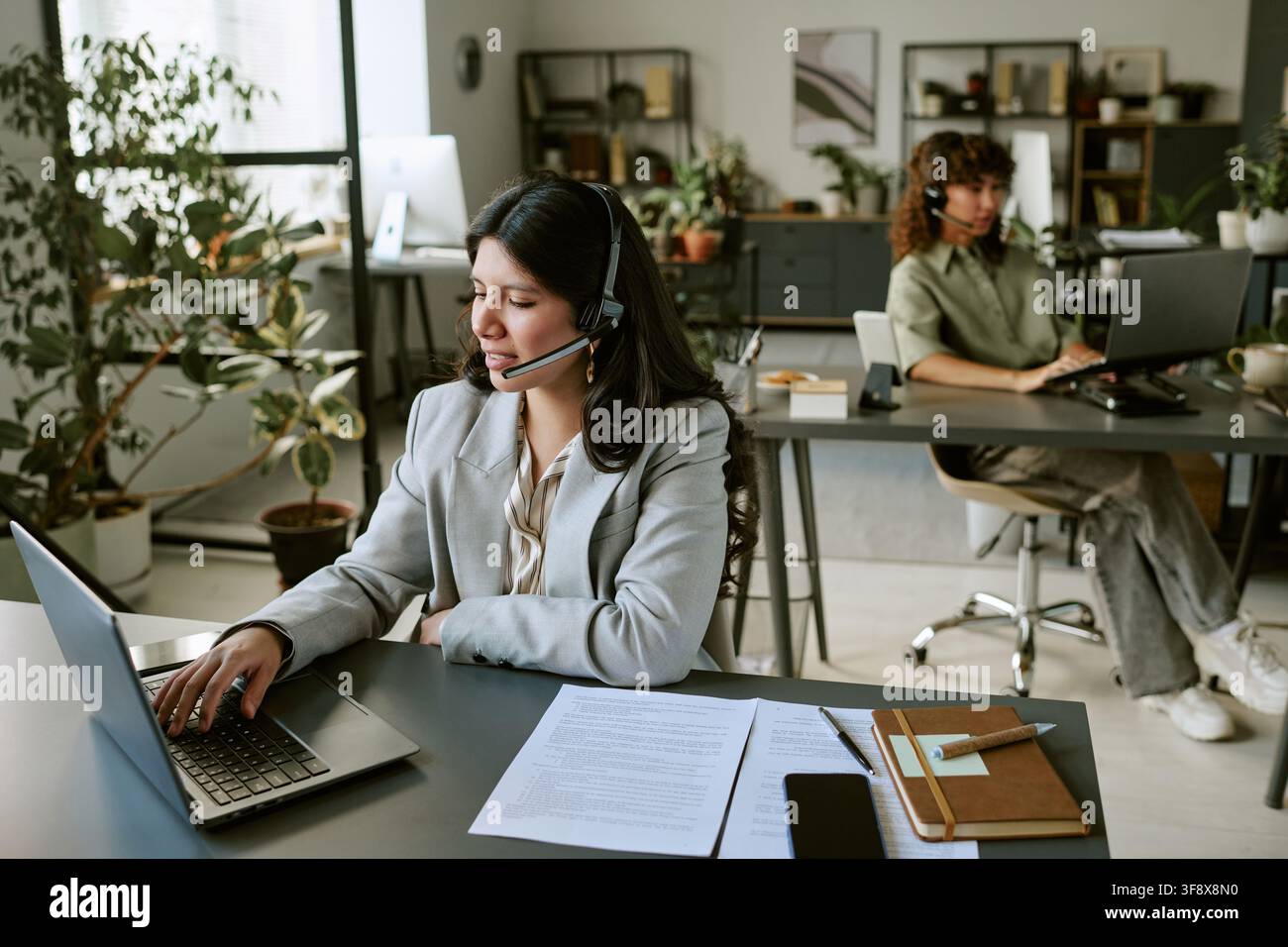 Diverse Female Operators Managing Customer Inquiries on Laptops Stock Photo