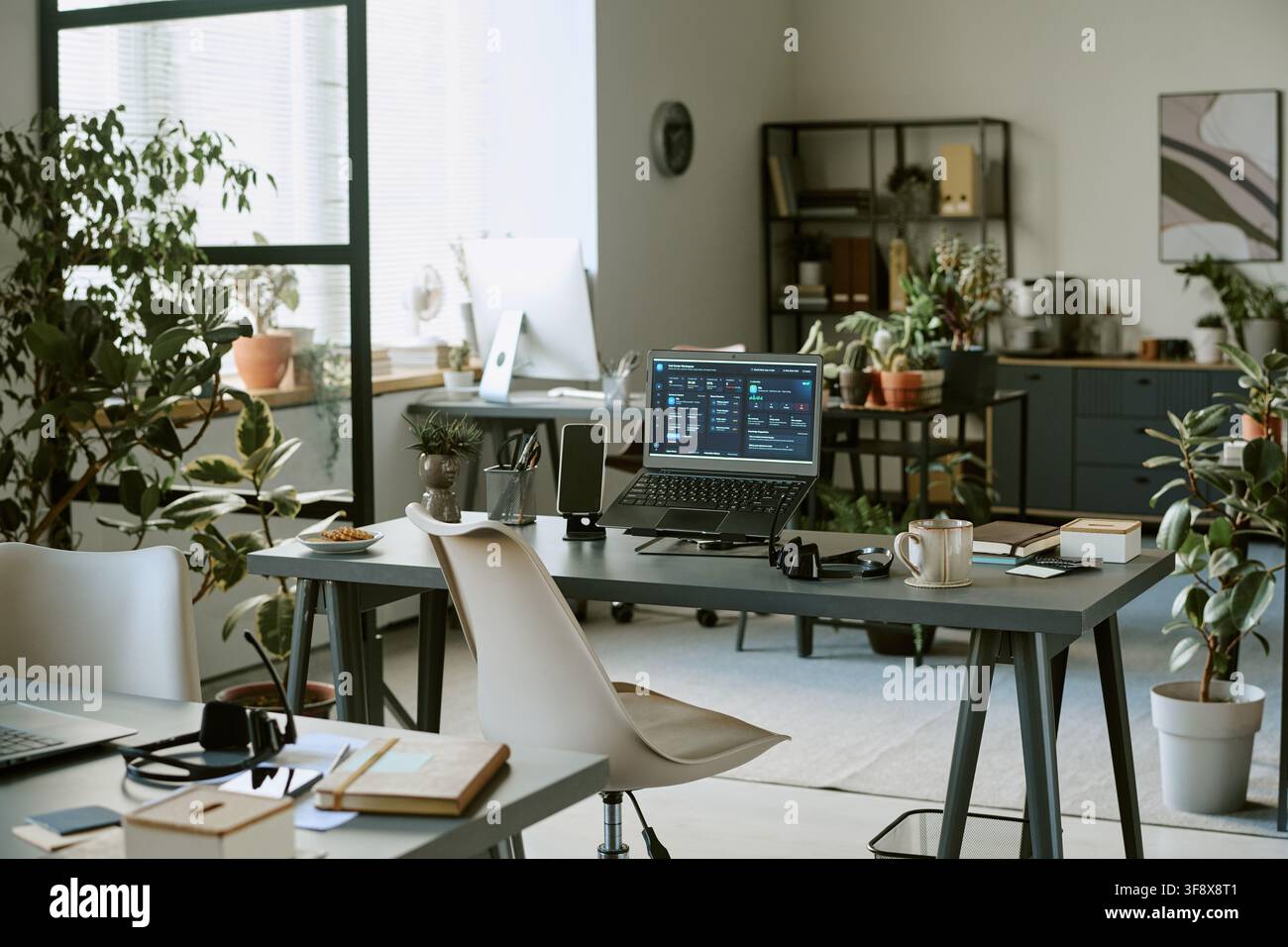 Empty Modern Office Workspace with Laptop Showing Business Dashboard Stock Photo