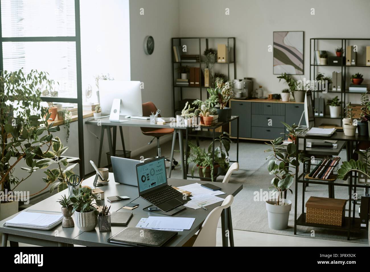 Empty Modern Office with Laptops and Plants on Desks Stock Photo