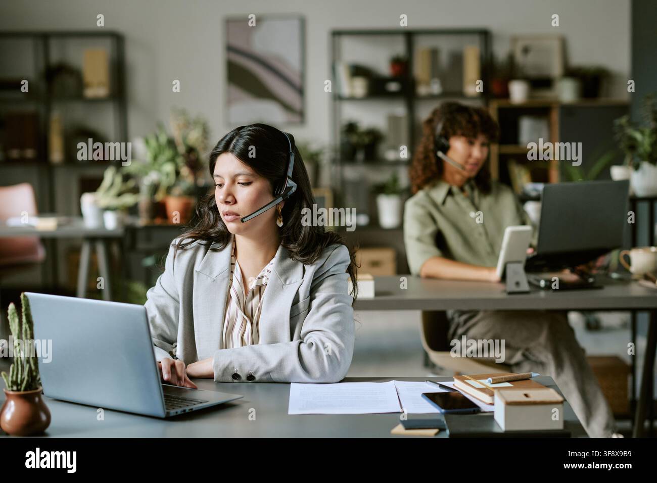 Two Diverse Women Working in Modern Call Center Stock Photo