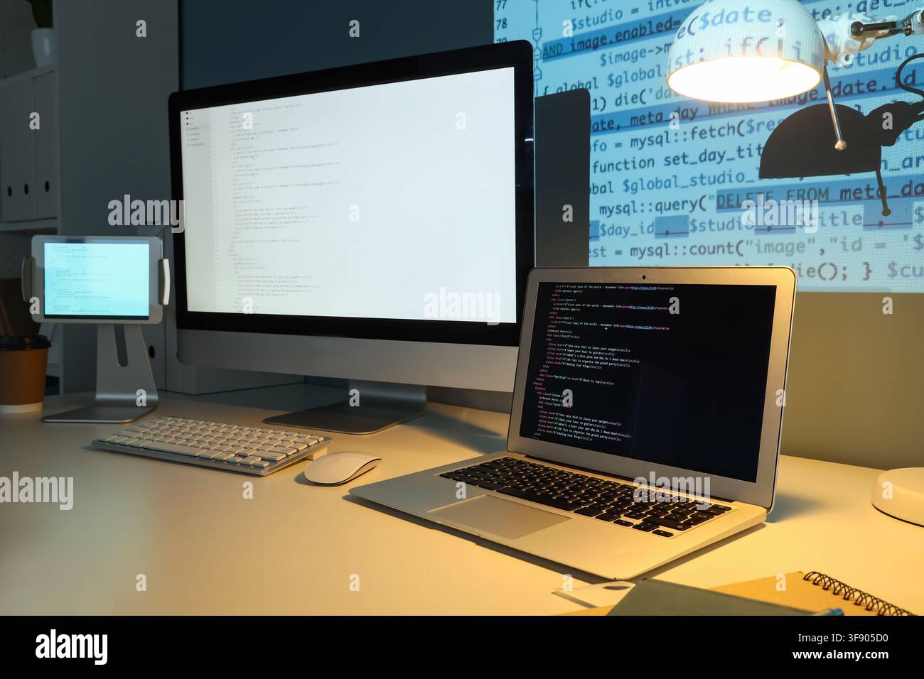 Developers desk with multiple screens displaying code, programming and software development concept, modern technology workspace Stock Photo
