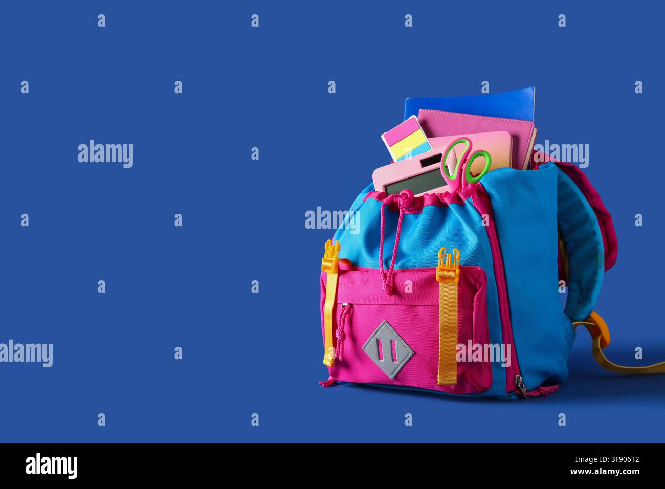 Stylish school backpack with different stationery on blue background Stock Photo