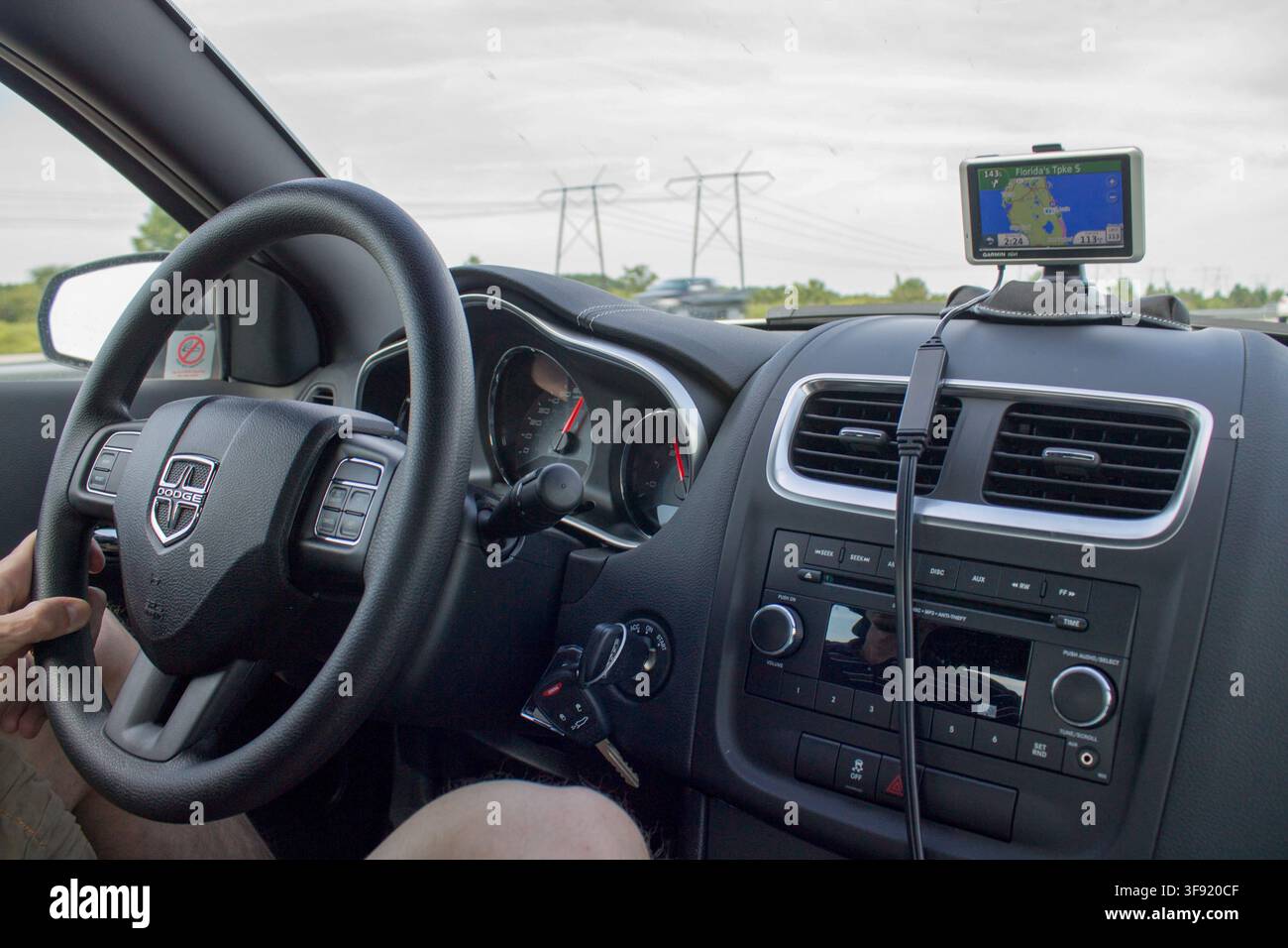 Driver using a GPS navigation device inside a Dodge car in the Caribbean. Stock Photo