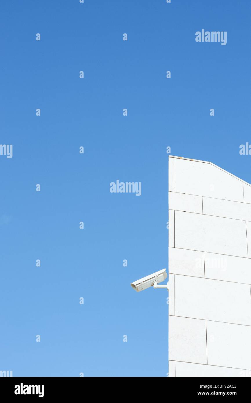 Security camera on modern building against blue sky Stock Photo