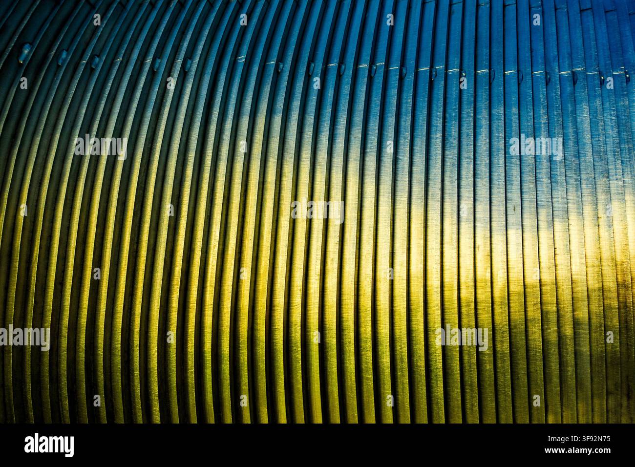 close-up of blue-toned metal bars with brushed surfaces, repeating parallel ridges and strong diagonal perspective Stock Photo