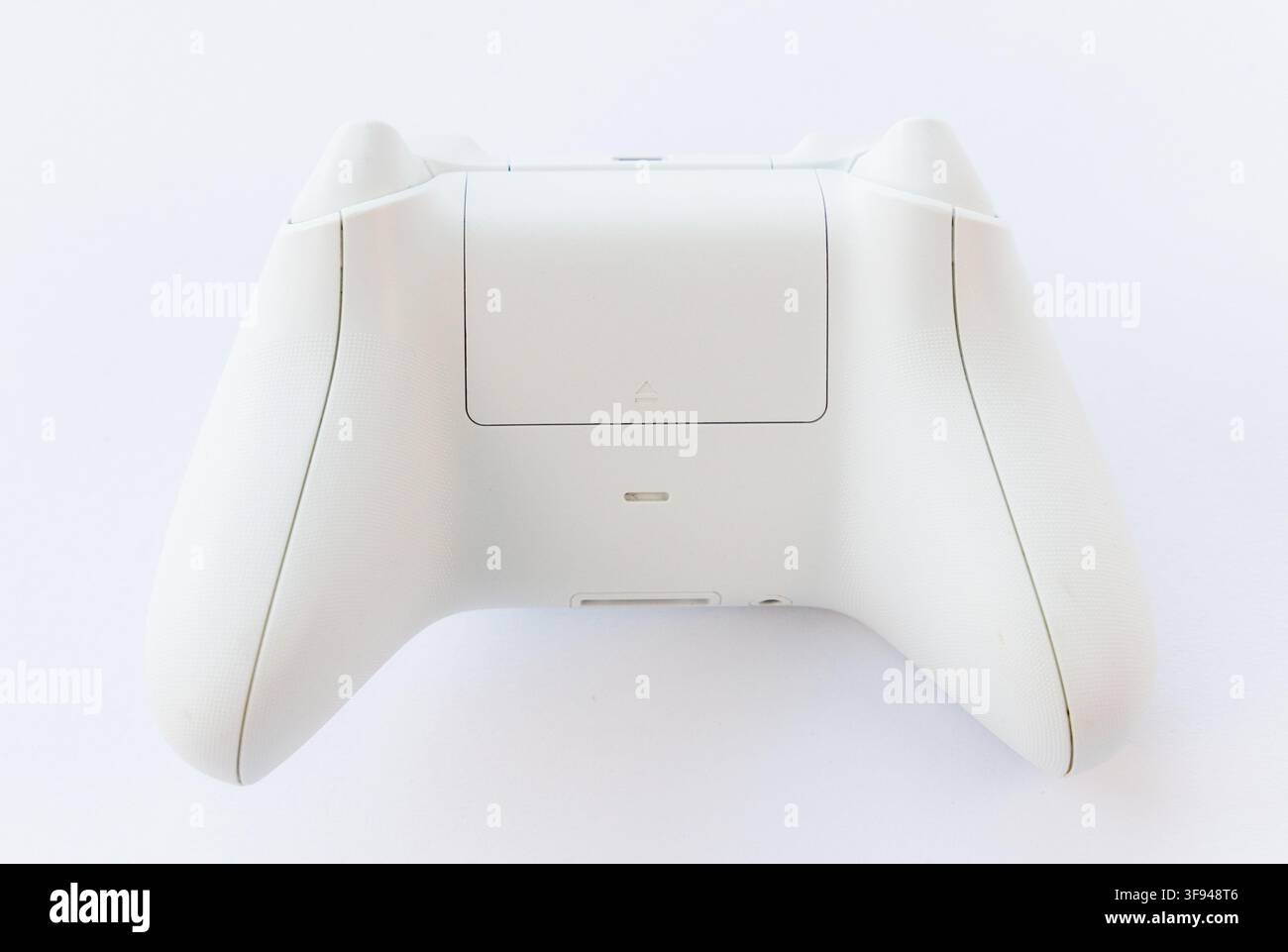 A white wireless gaming controllers back is shown on a white background Stock Photo