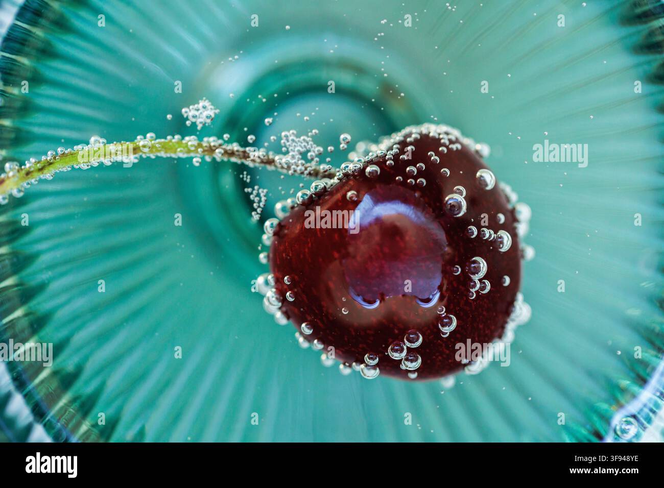 Cherry Floating in Sparkling Water with Bubbles Macro Background Stock Photo
