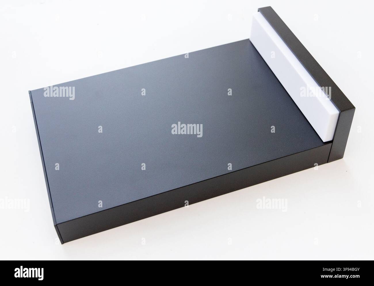 A sleek black rectangular object with a white accent on a plain white background Stock Photo