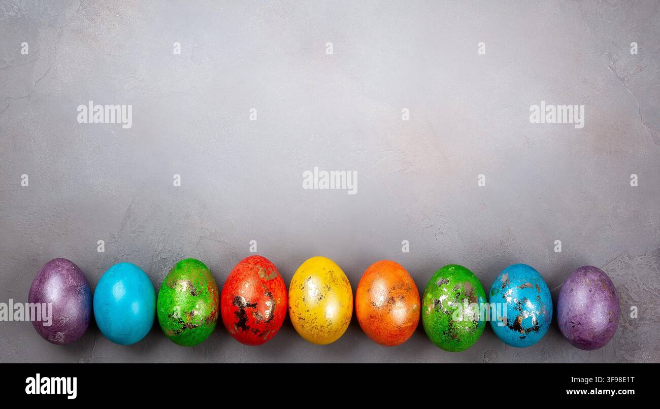 Easter concept wit colorful Easter eggs on grey background. Top view with copy space. Stock Photo