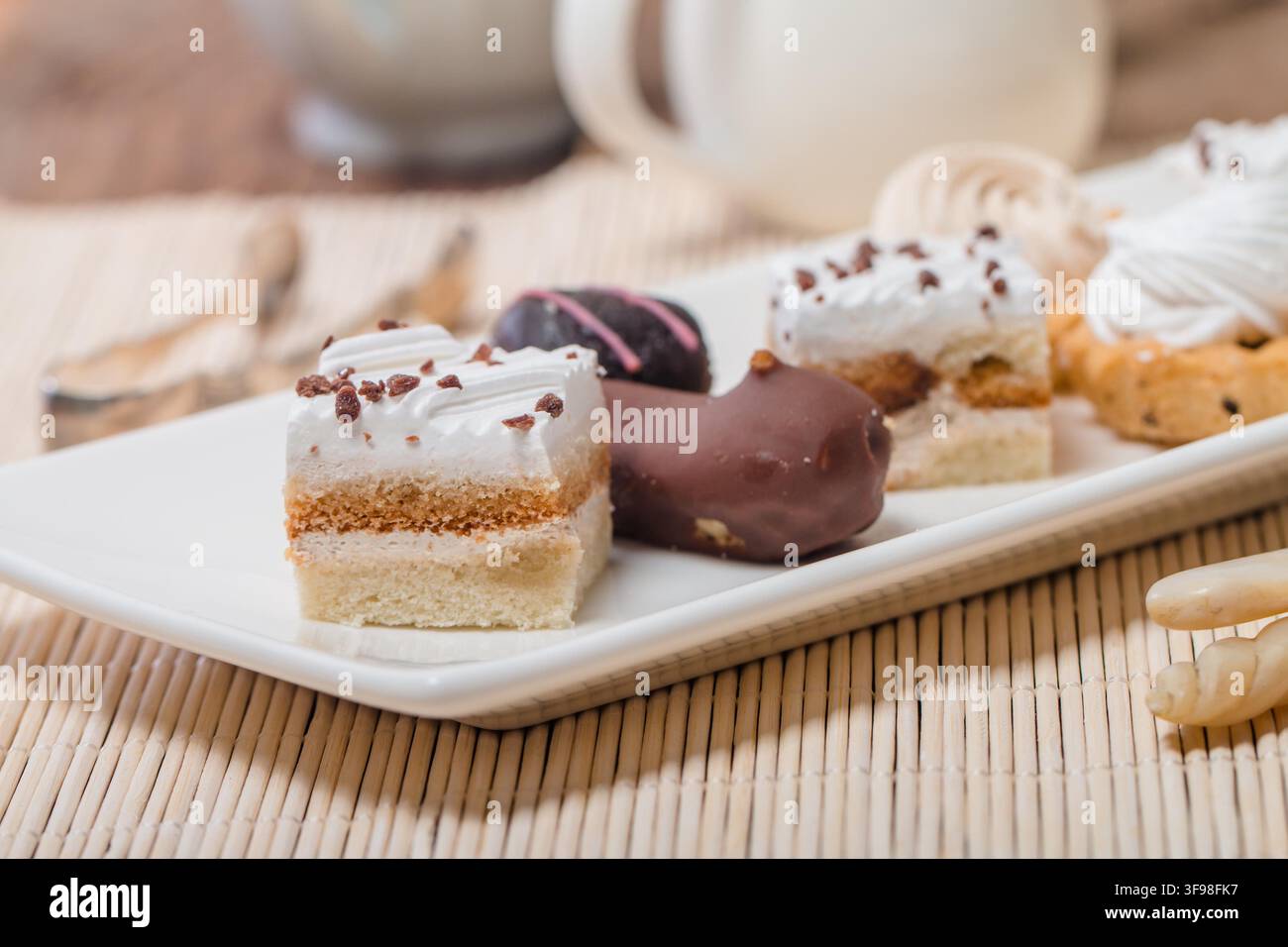Small cakes with different stuffing on white plate Stock Photo